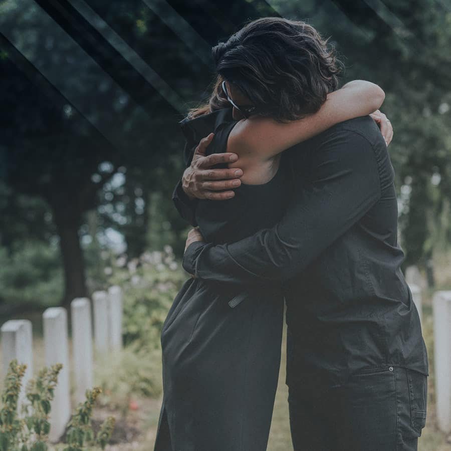 A couple hugs at a funeral