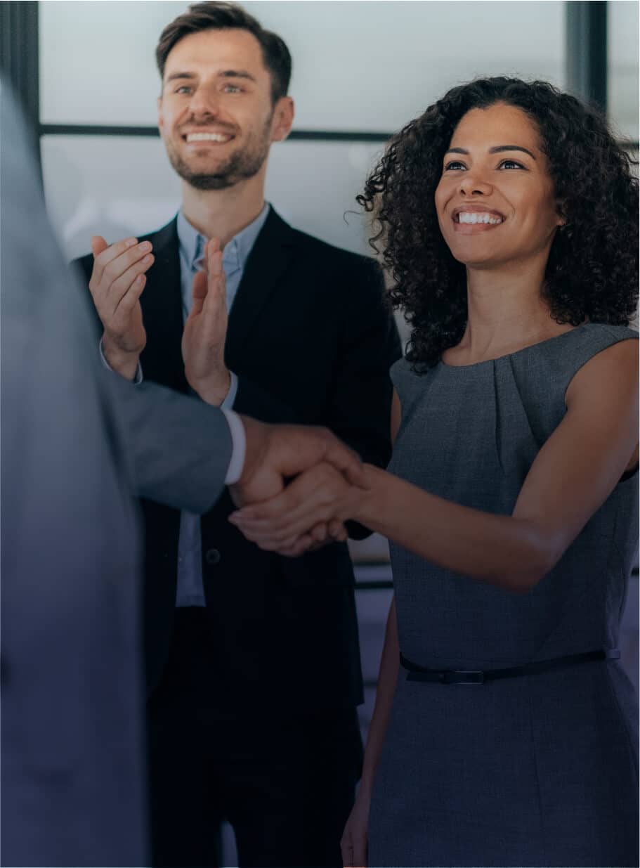 employees shaking hands in office